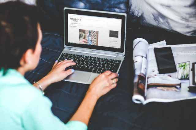 Reviewing campaign coverage on a laptop alongside a print magazine