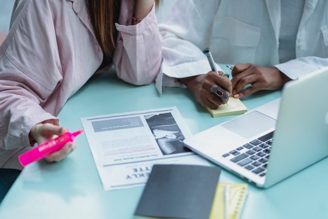 Two specialists reviewing a media strategy document together